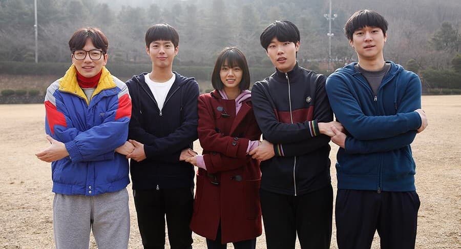Reply 1988 dizisinde ekip, ortada Hyeri olmak üzere okul bahçesinde el ele tutuşuyor